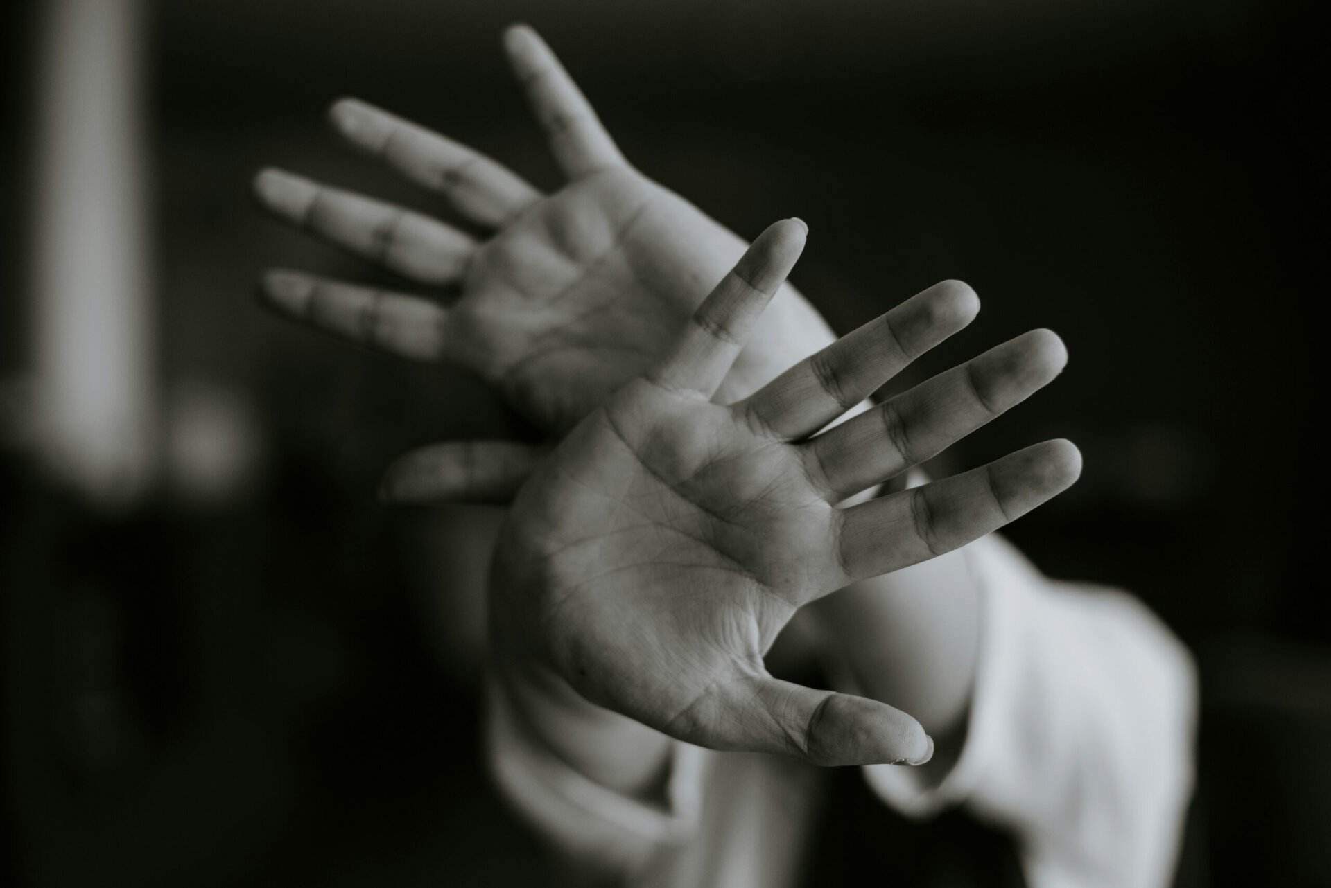 Black and white image of hands raised in prayer at World Methodist Evangelism event.