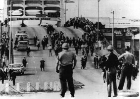 Black and white photo of state troopers facing peaceful marchers on the Edmund Pettus bridge