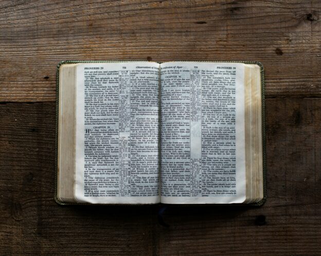 Bible open on a wooden surface, symbolizing faith and evangelism.