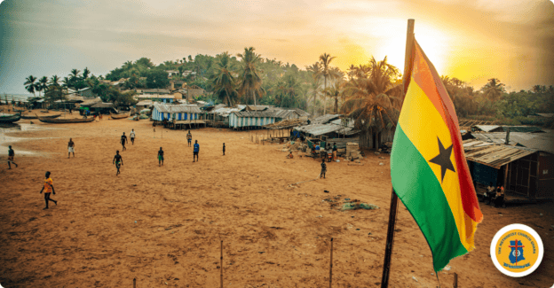 Community gathering at sunset with Ghana flag and local village scene.