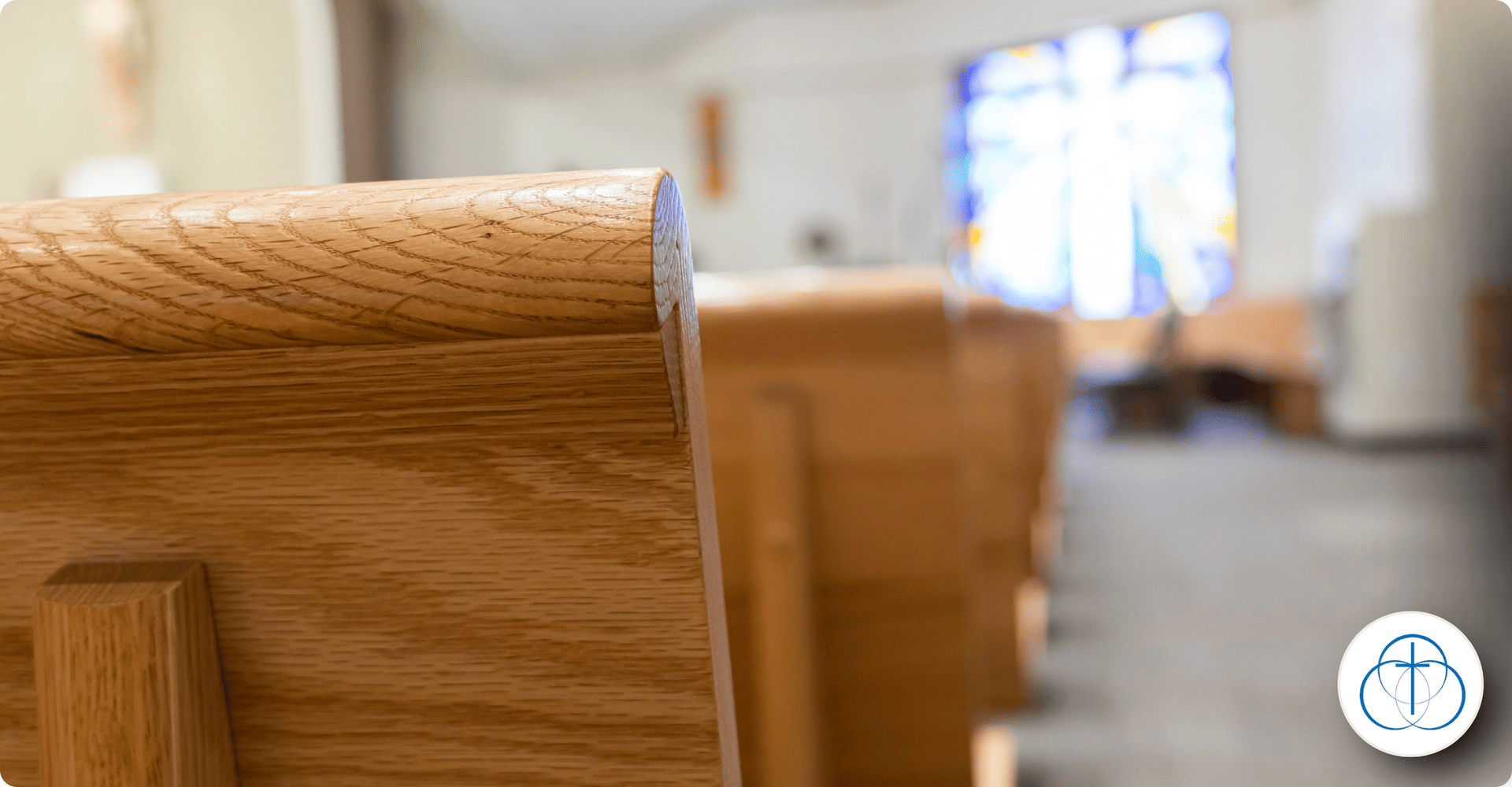 Wooden church pews with stained glass window in the background at a World Methodist Evangelism event.