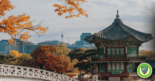 Traditional Korean pavilion with city skyline and autumn trees in Seoul.