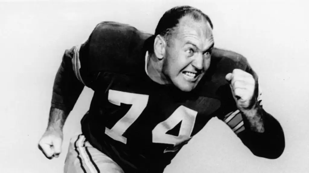 Person in sports jersey with number 74, smiling and celebrating.