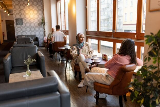 People engaging in conversation at a coffee shop for World Methodist Evangelism.